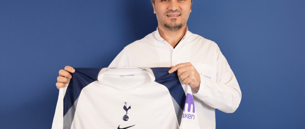 Bild zeigt, wie Dr. Abdulaziz Balwi ein Trikot des Premiere League Klubs Tottenham Hotspur in beiden Händen hält